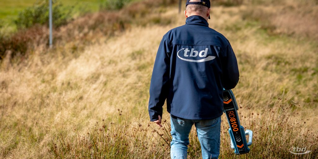 Akademie-Trainer Heiko Kischel demonstriert im Feld an unserer bundesweit einzigartigen Teststrecke die Suche nach einem unterirdischen Fehler in einer Leitung.