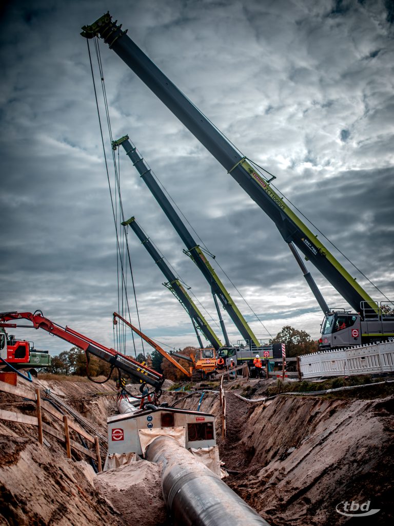 Gigantisches Bild: Ein Balett aus Mobilkranen, Raupen und Schweißkabine für die symbolische letzte Schweißnaht beim Festakt in Wiefelstede.
