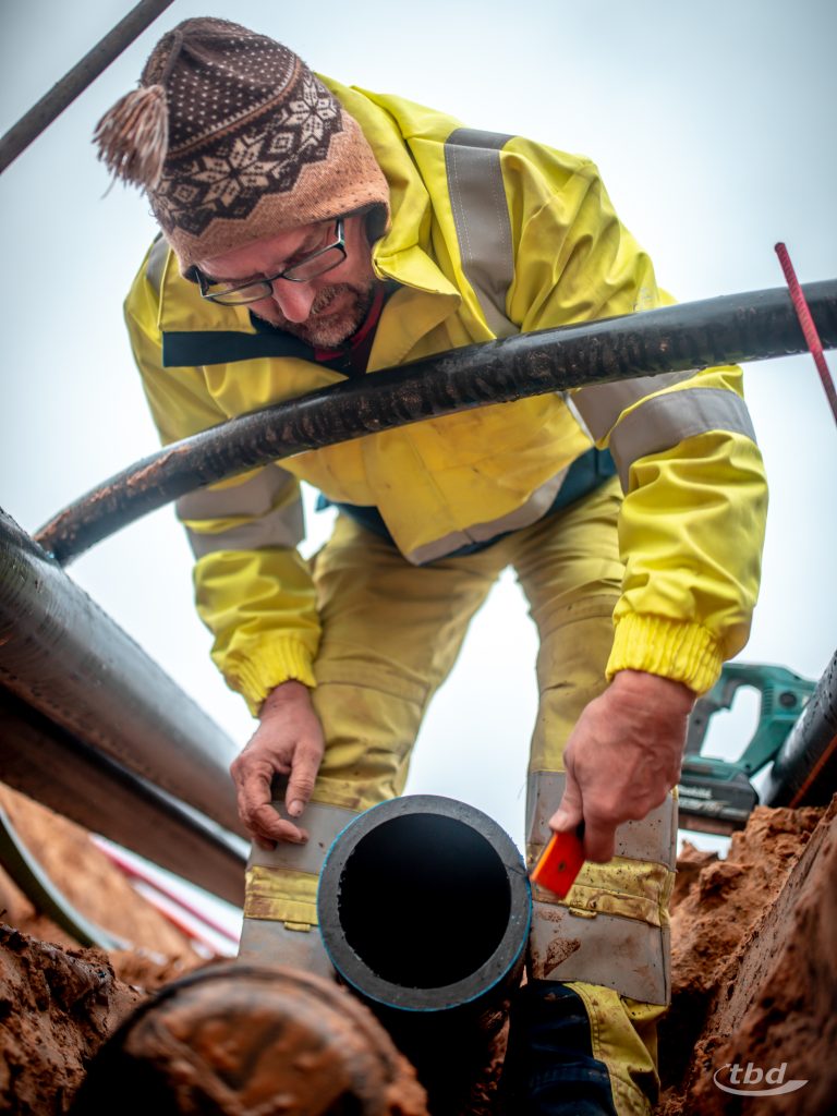 Bevor er die Muffe ansetzt, schmirgelt Knut das Rohrende nochmal sauber ab.