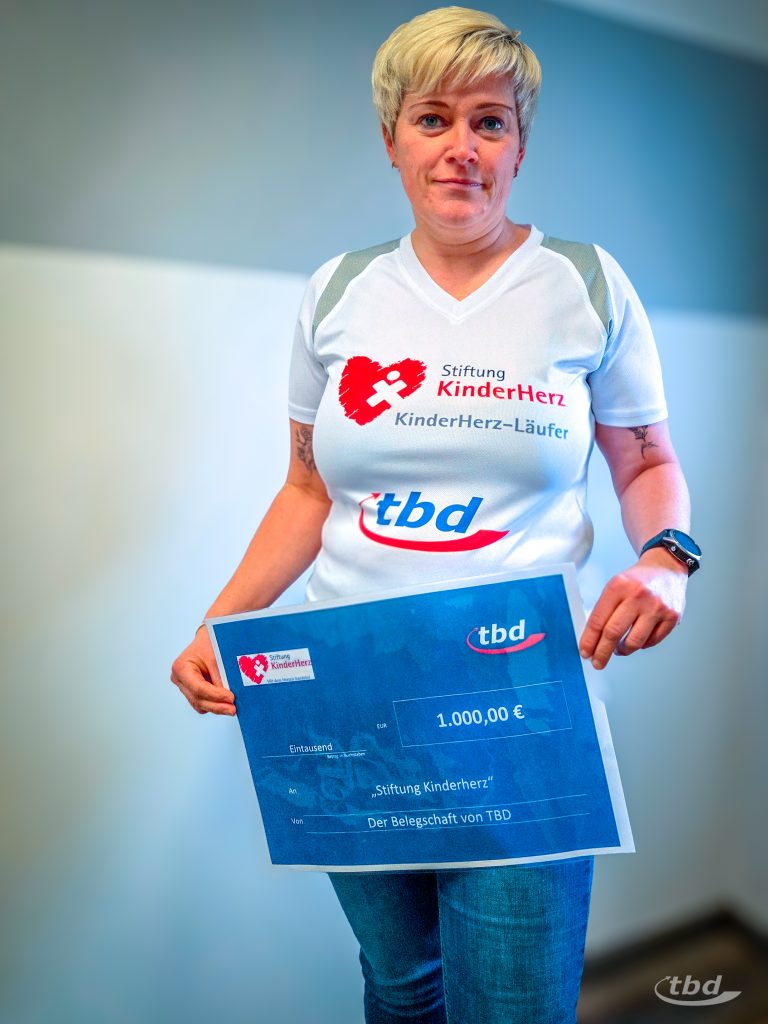 Peggy Berger mit dem Botschafter-Shirt und einem symbolischen Scheck für die Stiftung HerzKinder.