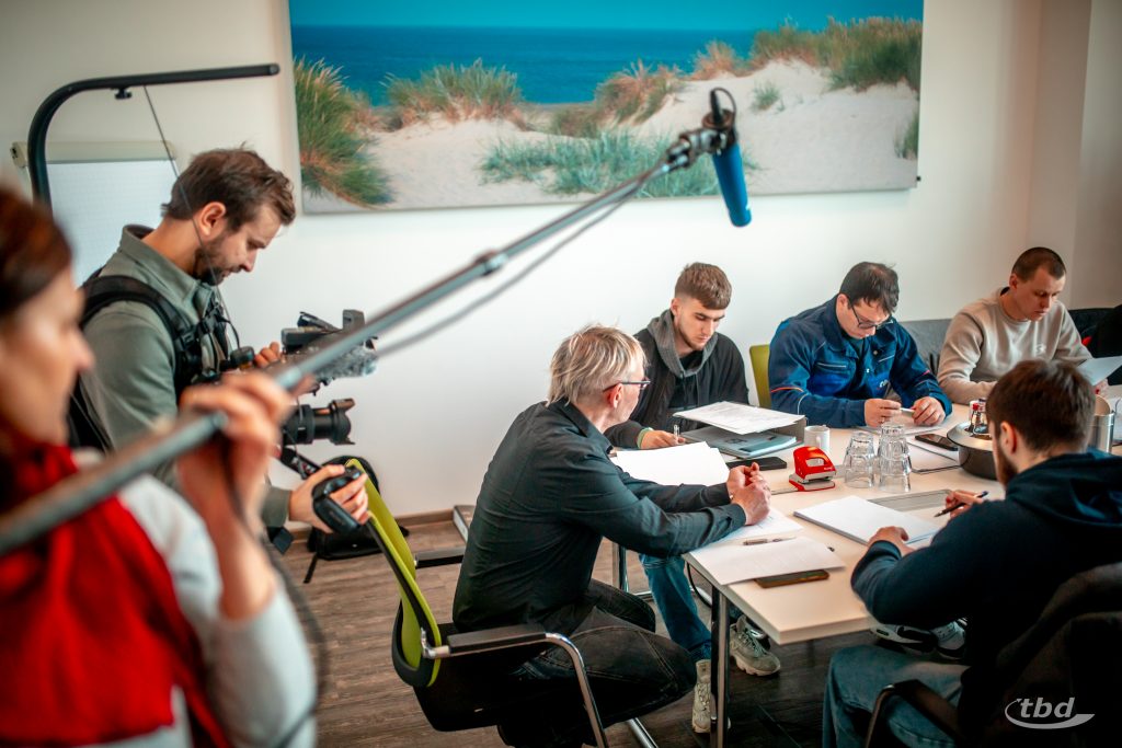 Kameramann Daniel und Tontechnikerin Julia zeichnen eine Sprachunterrichtszene auf.