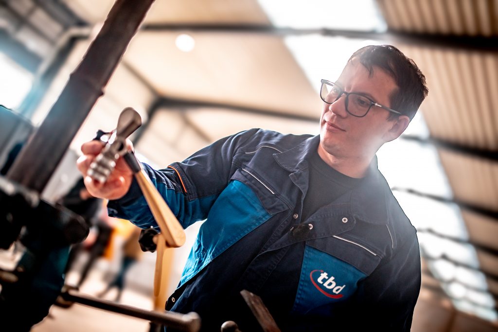 Oleksii richtet den Kollimator, der die Strahlen bündelt und abschirmt, mithilfe einer Ellipsenzange vor der Schweißnaht aus.