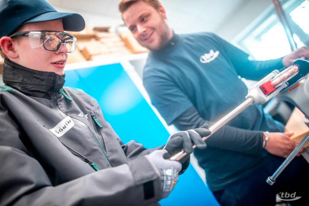 Das braucht Kraft: Sebastian biegt beim Zukunftstag ein Kupferrohr, unser Azubi Jannick assistiert ihm.