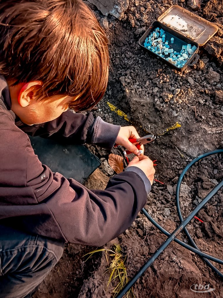 Leon hilft beim Abisolieren von Adern eines kaputten Telekommunikationskabels.